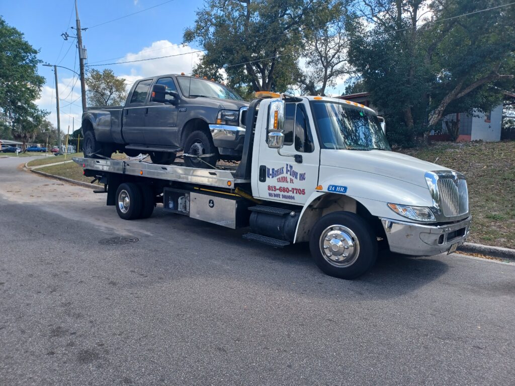 A grey 4x4 towed on a tow truck