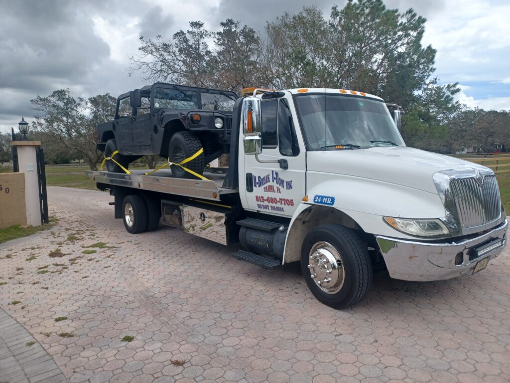 A black jeep towed on a tow truck
