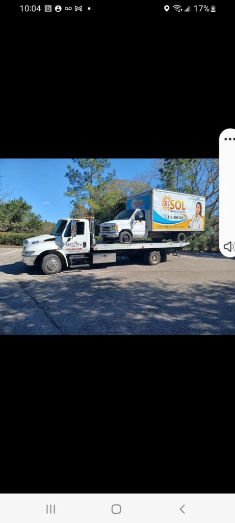 A screenshot of a tow truck carrying a medium pick up